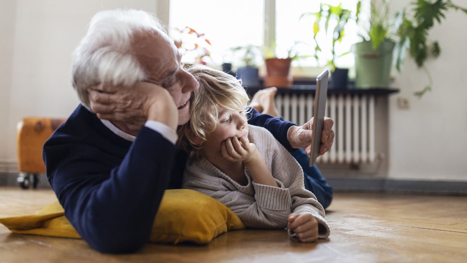 Abuelo y nieto mirando una tableta en casa
